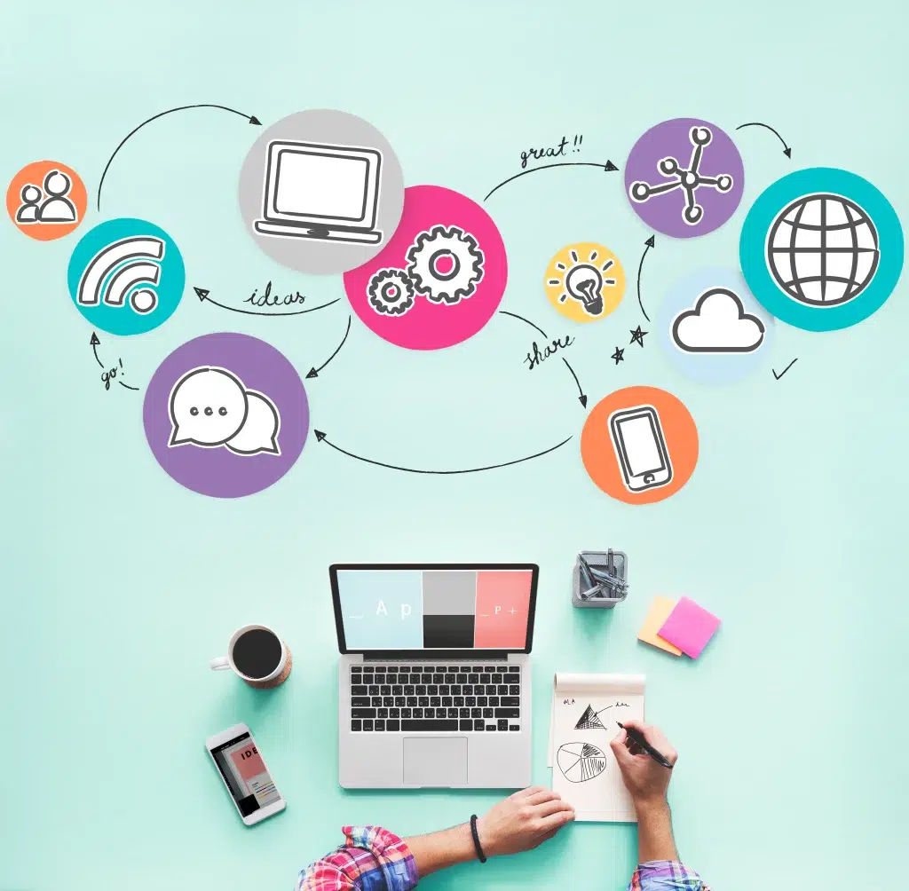 Persona trabajando con un portátil y un cuaderno, rodeada de iconos coloridos que representan ideas, comunicación y tecnología.